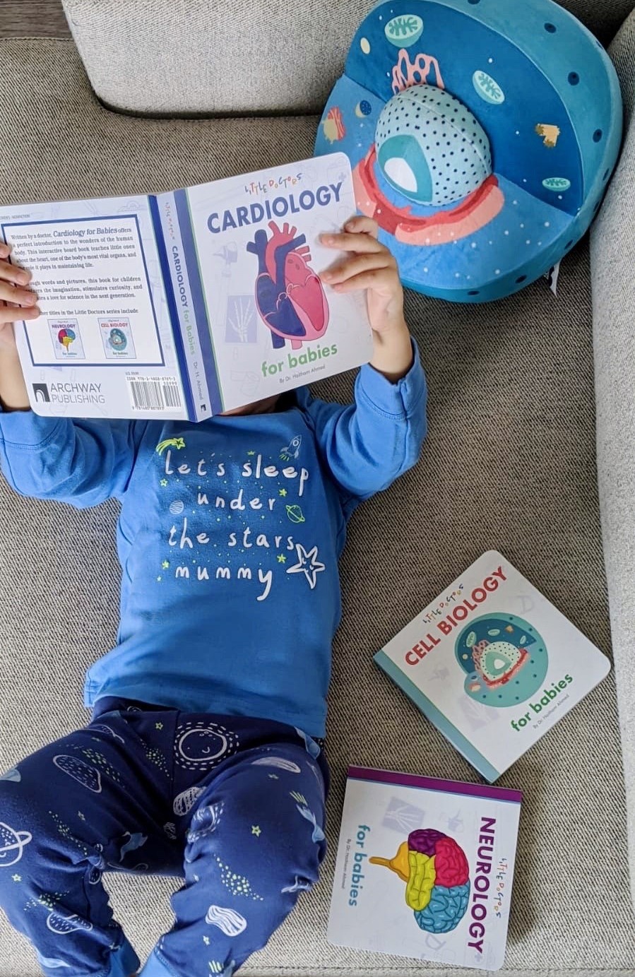 Baby reading Little Doctors Cardiology for Babies board book by Dr. Haitham Ahmed